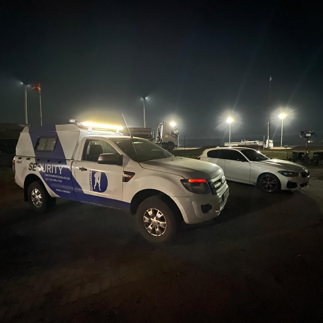 Patrol vehicles under floodlights at night